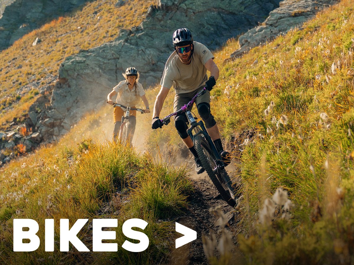 Rider biking on a dirt trail through a grassy landscape, labeled “Bikes.”